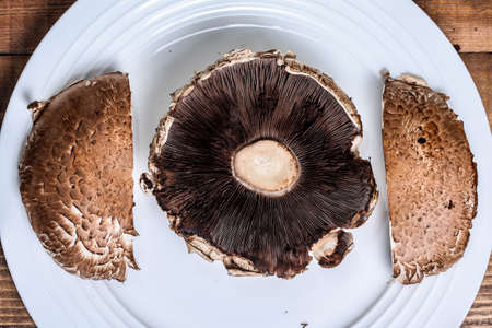 Two portabella mushroom caps on white plate
