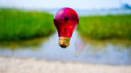 Red light bulb with reflection on beach abstractの写真素材