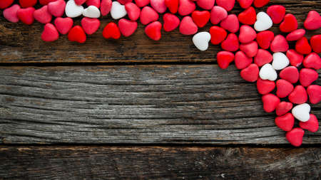 Colorful candy hearts  background with copy space on rustic wooden boardsの写真素材