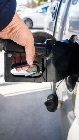 Close up from hand filing up gasoline at pumpの写真素材