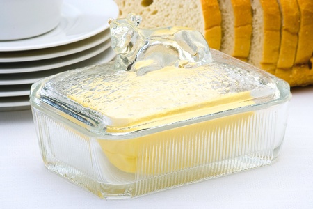 butter in the butter dish on white tableの写真素材