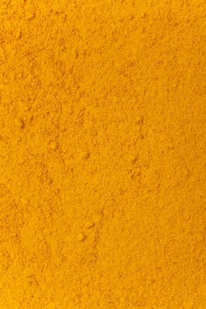 turmeric powder background, yellow grain abstract textureの写真素材