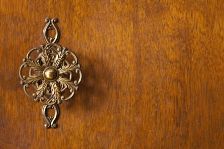 detail of wardrobe door or wooden brown background with decorative knob on left sideの写真素材