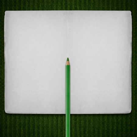 open notebook with green crayon on stripe pattern canvas backgroundの写真素材
