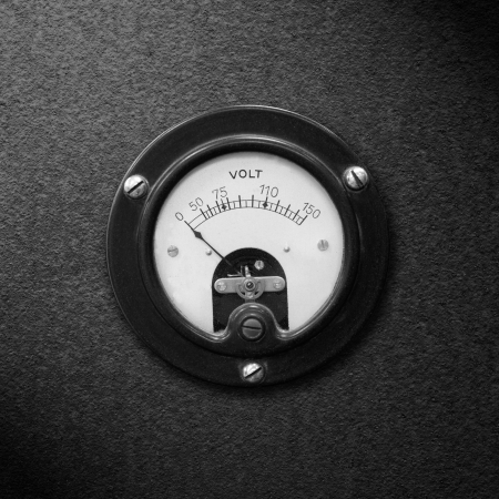 old voltmeter on black metal rough pattern texture or vintage electric measurementの写真素材