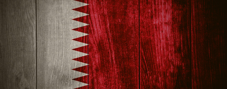 flag of Qatar or Qatari banner on wooden background