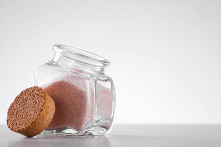 pink Himalayan salt in glass jar on white background with place for text on rightの写真素材