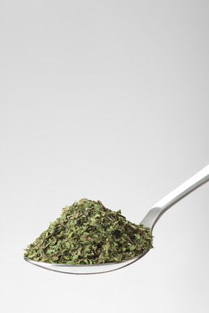 spoon of green dried herbs on white background with empty place for textの写真素材