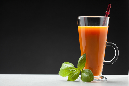 carrot or orange juice in glass on white background with blank space for textの写真素材