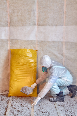 Master stacked cellulose insulation in the floor, Insulated floor, a warm home, eco-friendly insulation, insulation paper, builder at workの写真素材