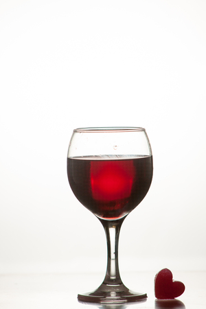 Glass of red Fina in a glass isolated on a white background with a romantic heart iceの写真素材