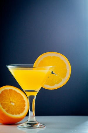 Isolated drink. Glass of orange juice and slices of orange fruit isolated on dark backgroundの写真素材