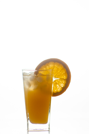 Isolated drink. Glass of orange juice and slices of orange fruit isolated on dark backgroundの写真素材
