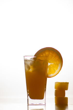 Isolated drink. Glass of orange juice and slices of orange fruit isolated on dark backgroundの写真素材