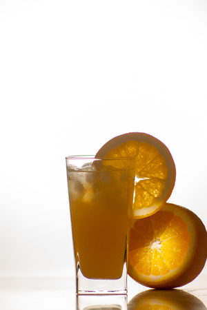 Isolated drink. Glass of orange juice and slices of orange fruit isolated on dark backgroundの写真素材