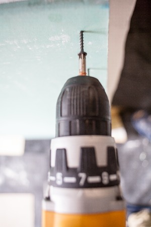 interior house alterations works Drywall Construction worker holding the hand drill electric screwdriverの写真素材