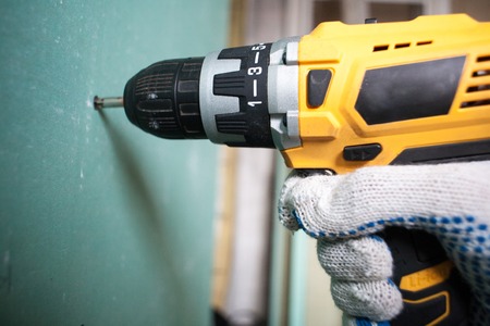 interior house alterations works Drywall Construction worker holding the hand drill electric screwdriverの写真素材