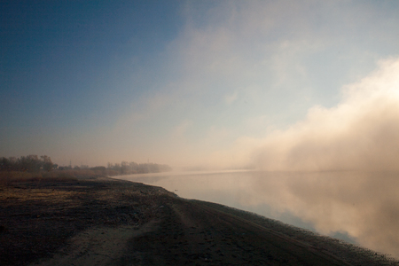 Dense fog on the river in the early morning at dawn with sunriseの写真素材