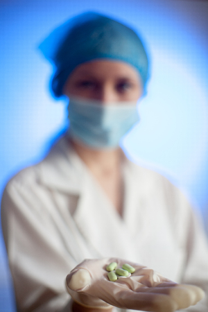 A nurse in a hospital with medication tablets in his hand for the sick, a cure for the disease, a pill of cancer, a treatment for multiple sclerosis and AIDSの写真素材