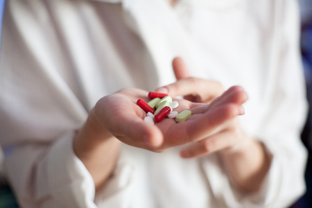 A nurse in a hospital with medication tablets in his hand for the sick, a cure for the disease, a pill of cancer, a treatment for multiple sclerosis and AIDSの写真素材