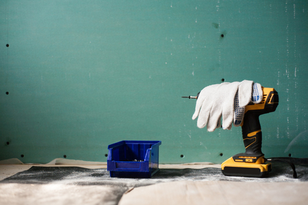 interior house alterations works Drywall Construction worker holding the hand drill electric screwdriverの写真素材