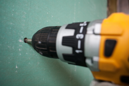 interior house alterations works Drywall Construction worker holding the hand drill electric screwdriverの写真素材