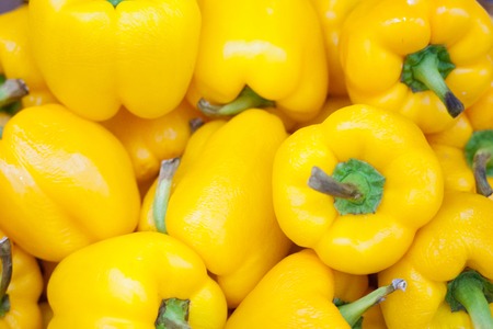 Yellow pepper background lots of sweet yellow peppers on a pile on store shelves selling sweet yellow peppers top viewの写真素材
