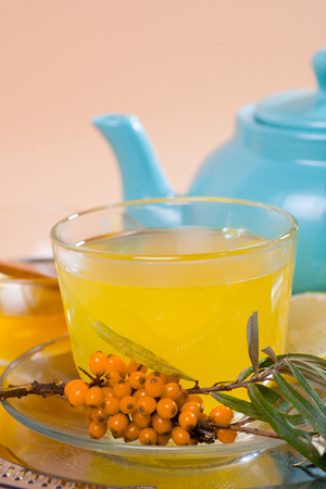 Tea made from sea buckthorn berries healthy for health delicious, saturated with vitamins surrounded by berries and sea buckthorn leaves for family tea drinking and maintaining health in the bodyの写真素材