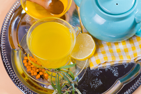 Tea made from sea buckthorn berries healthy for health delicious, saturated with vitamins surrounded by berries and sea buckthorn leaves for family tea drinking and maintaining health in the bodyの写真素材