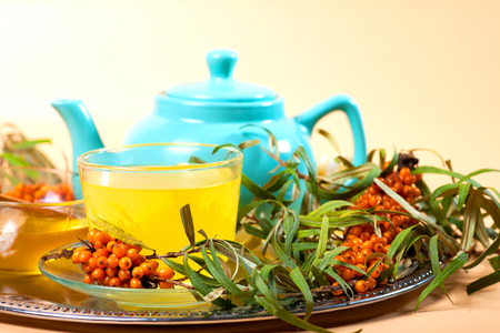 Tea made from sea buckthorn berries healthy for health delicious, saturated with vitamins surrounded by berries and sea buckthorn leaves for family tea drinking and maintaining health in the bodyの写真素材