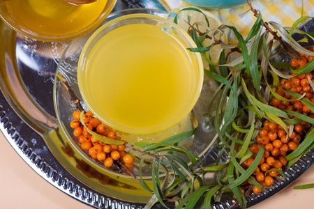 Tea made from sea buckthorn berries healthy for health delicious, saturated with vitamins surrounded by berries and sea buckthorn leaves for family tea drinking and maintaining health in the bodyの写真素材