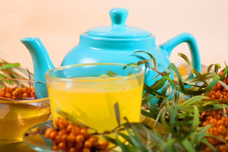 Tea made from sea buckthorn berries healthy for health delicious, saturated with vitamins surrounded by berries and sea buckthorn leaves for family tea drinking and maintaining health in the bodyの写真素材