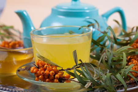 Tea made from sea buckthorn berries healthy for health delicious, saturated with vitamins surrounded by berries and sea buckthorn leaves for family tea drinking and maintaining health in the bodyの写真素材