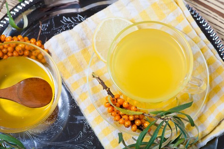 Tea made from sea buckthorn berries healthy for health delicious, saturated with vitamins surrounded by berries and sea buckthorn leaves and maintaining health in the body top viewの写真素材