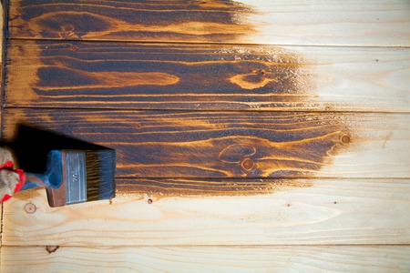 Paint the boards with a brush and bowl of white coating color put on wood boardの写真素材