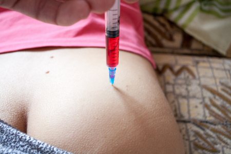 Injection of vitamin in the gluteus muscle at homeの写真素材