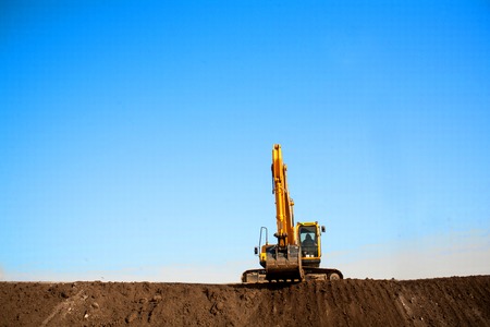 A large construction excavator of yellow color on the construction site in a quarry for quarryingの写真素材