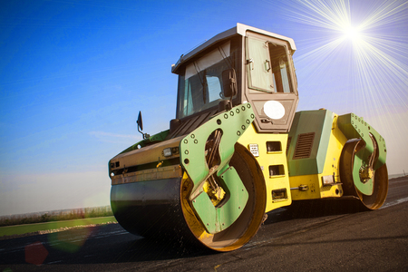 the road rollers working on the new road construction site asphalt compactorの写真素材