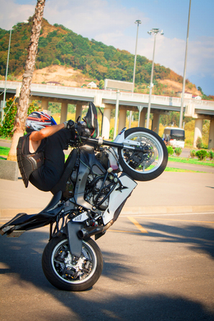 stuntrading on motorcycle stunts while driving on the rear wheel of a Willie stoppix stunt-riding on a sportbikeの写真素材