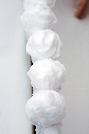 real snowballs with their hands clasped from the fresh snow in winter on the streetの写真素材