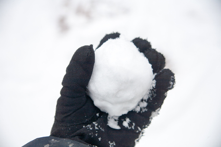 real snowballs with their hands clasped from the fresh snow in winter on the streetの写真素材