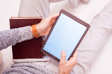 Office worker businessman holding a digital tablet with a white screen working online in the office at the tableの写真素材