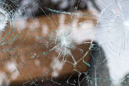 broken glass of a car with cracks in a circle
