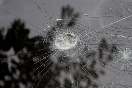 broken glass of a car with cracks in a circle