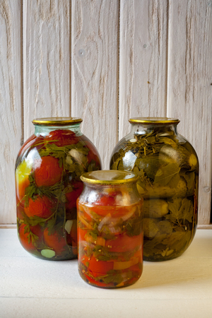 canned tomatoes in glass jars. Canned vegetables for storage in the cellar in the winter. Vegetarian marinated vegetable salads.の写真素材