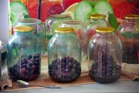 canning cherries in glass jars for the winter. Homemade canned fruit stocks in their own juice. Cherry compote with their own hands.の写真素材