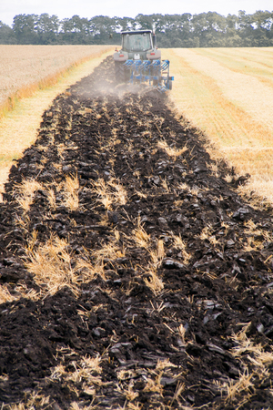 Tractor preparing land for sowing. Farmer in tractor preparing land with seedbed cultivatorの写真素材