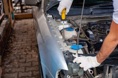 mechanic men with wrench repairing car engine at workshop - auto service, repair, maintenance and...