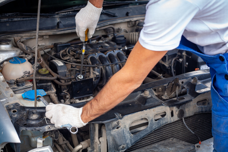 mechanic men with wrench repairing car engine at workshop - auto service, repair, maintenance and people concept.の写真素材
