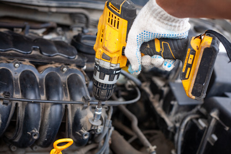 mechanic men with wrench repairing car engine at workshop - auto service, repair, maintenance and people concept.の写真素材